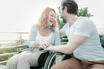 Facial expressions. Cheerful bearded man sitting in semi position and turning head while spending weekends with her couple