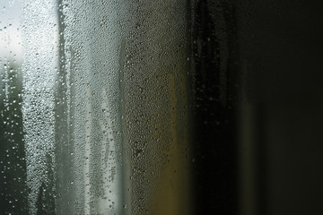 Droplets or drops of water on misted glass.