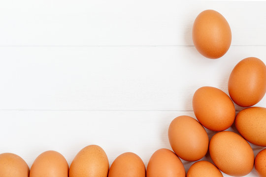 fresh or raw brown eggs on white wooden background, top view, flat lay with copy space, food ingredient