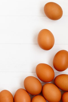 fresh or raw brown eggs on white wooden background, top view, flat lay with copy space, food ingredient