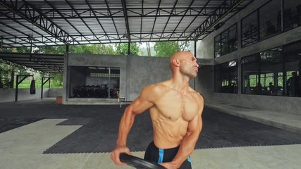 Man training with barbell pancake for professional bodybuilding in sports club