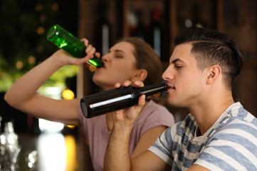 Young couple drinking in bar. Alcoholism problem