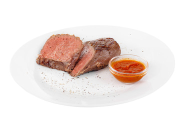 Steak beef, pork, lamb, grilled meat, barbecue, on a plate isolated white background. Tomato, spicy, red sauce. Juicy fillet, medium, strong roast. For the menu in the restaurant, bar Side view