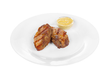 Steak of dark beef, pork, lamb, grilled meat, barbecue, on a plate isolated white background. Mustard, yellow sauce. Juicy fillet, medium, strong roast. For the menu in the restaurant, bar. Side view