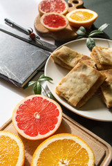 Apple pie, oranges and notebook with pen