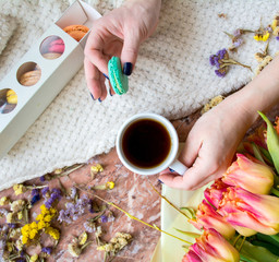 Tea time flat lay with cup of tea, pink tulip  and macaroons