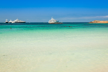 Luxury yachts in turquoise beach of Formentera Illetes