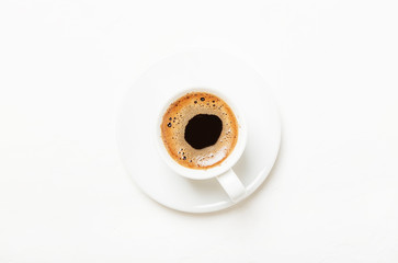 White cup of black coffee espresso with foam, white background, top view