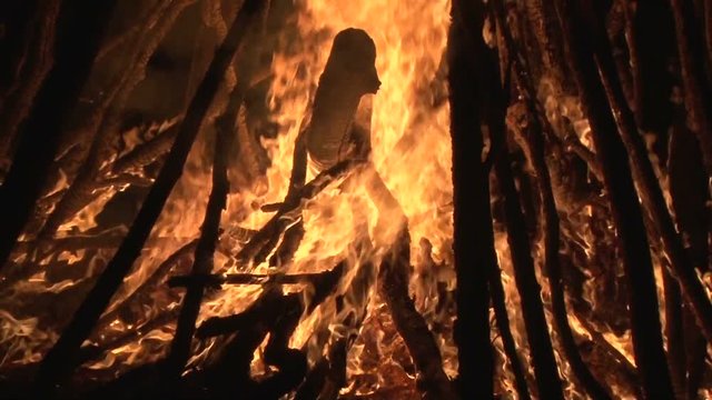 night fire sparks flying in the dark night sky, big night bonfire in a clearing in the forest