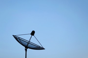 Satellite dish on roof with blue sky background. Technology concept.