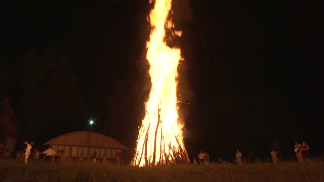 Big night bonfire burns in a clearing in the forest