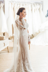 Fototapeta premium Young bride in white dress in wedding fashion shop