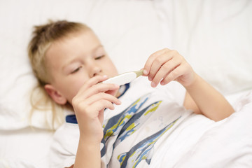 little boy looks at the thermometer. selective focus