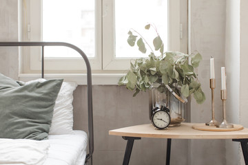 Bedroom interior with clock plant pot on wooden table
