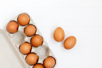 fresh or raw brown eggs on white wooden background, top view, flat lay with copy space, food ingredient