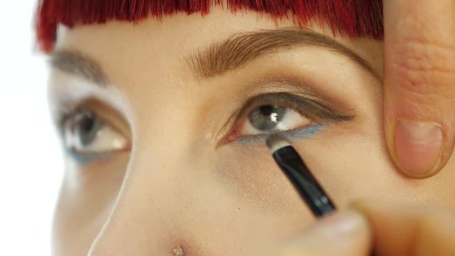 Professional make-up artist applying eyeliner on eye. makeup and fashion concept