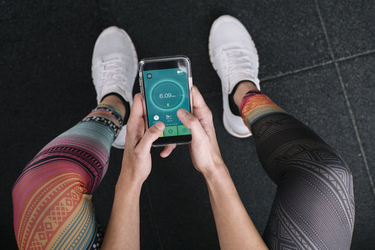 Woman Using A Running App In Smartphone