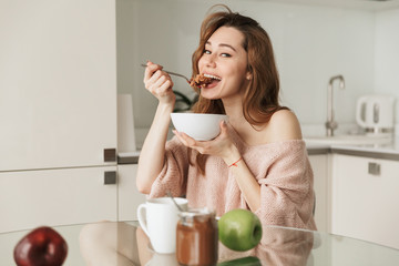 Portrait of a satisfied young woman having healthy breakfast