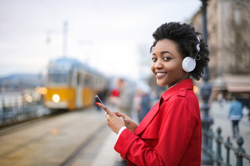 Fototapeta premium Girl listening music, while waiting for the train