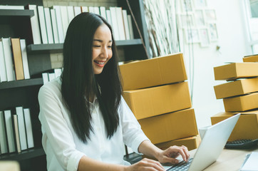 young asian businesswoman sitting happy to typewriter online shopping working with laptop and box package, instant process style