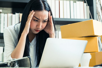 young woman headache, serious and pressure in problem working at home office with laptop and box package, high contrast process style