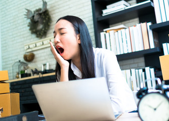 businesswoman yawn sleepy in working time at home office with laptop and clock, light process style