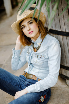 Woman in western wear in cowboy hat, jeans and cowboy boots.