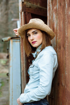 Woman in western wear in cowboy hat, jeans and cowboy boots.