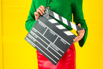 Attractive woman with a clapperboard in her arms