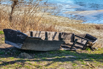 Naklejka premium abandoned and damaged wooden boat on the coast