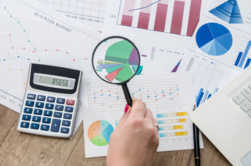 Analysing business graphs with magnifying glass .