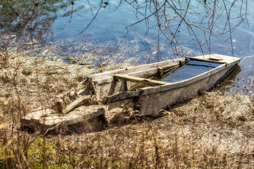 Naklejka premium abandoned and damaged wooden boat on the coast