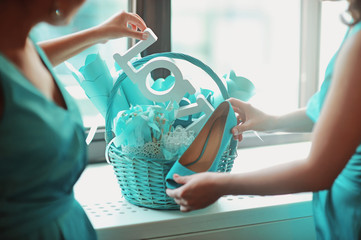 Blue turquoise color wedding bridal details in basket at the window. Wooden letters LOVE in hands...