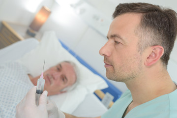 Fototapeta premium Medic preparing injection for male patient