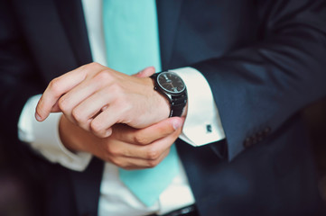 The man in the white shirt and black suit wearing watches close up macro