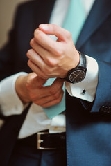 The man in the white shirt and black suit wearing watches close up macro