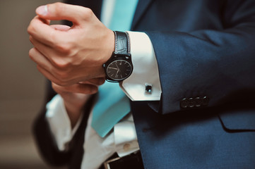 Fototapeta premium The man in the white shirt and black suit wearing watches close up macro