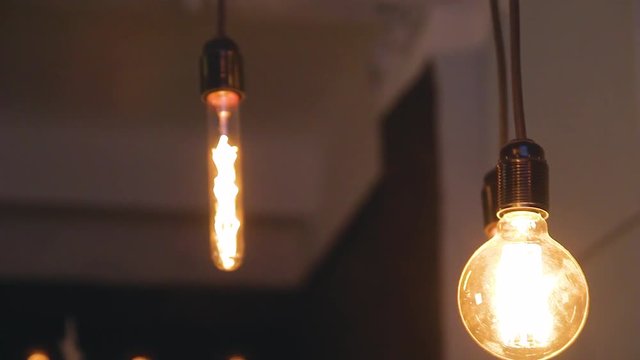 burning retro light bulbs on black background