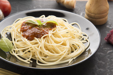 Spaghetti bolognese in black plate on vintage table background,Spaghetti with Spicy Mixed sauce and meat