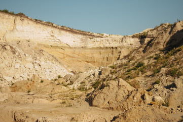 Fototapeta na wymiar Opencast mining quarry. This area has been mined for sand and other minerals. Restoration of a part of the mined glass sand quarry. Dunes of the sand quarry. Landscapes and Nature