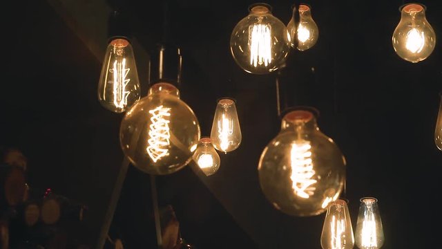 burning retro light bulbs on black background