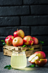 Cinnamon apple kombucha and fresh apples in wooden box on concrete background. Selective focus, space for text.
