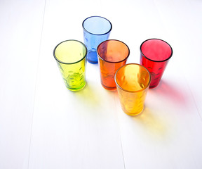 multicolored glass cups on white background