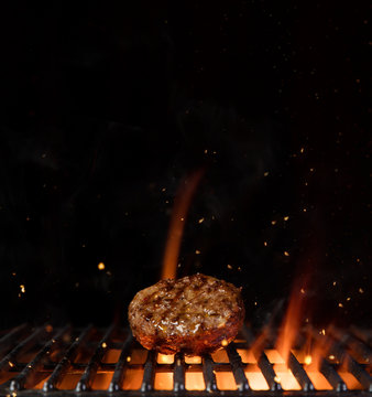 Piece of minced meal for hamburger placed on grill grid.