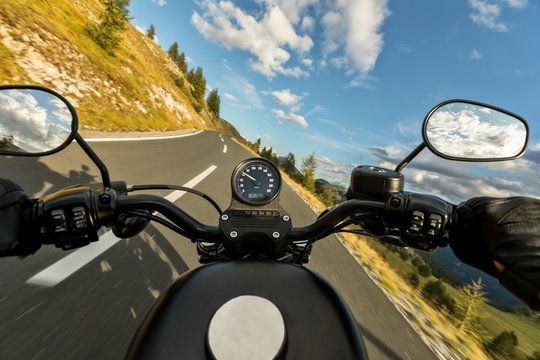 Fototapeta POV of motorbiker holding steering bar, riding in Alps