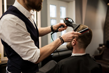 Barber styling customer hair with drier