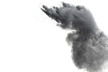 Black powder explosion against white background.The particles of charcoal splattered on white...