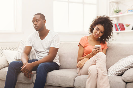 African-american couple at home, girl texting