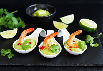 Delicate avocado soup with shrimps, lime and cilantro.