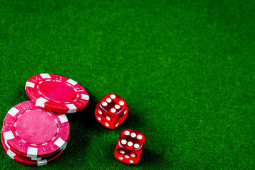 poker chips and dice on green background top view